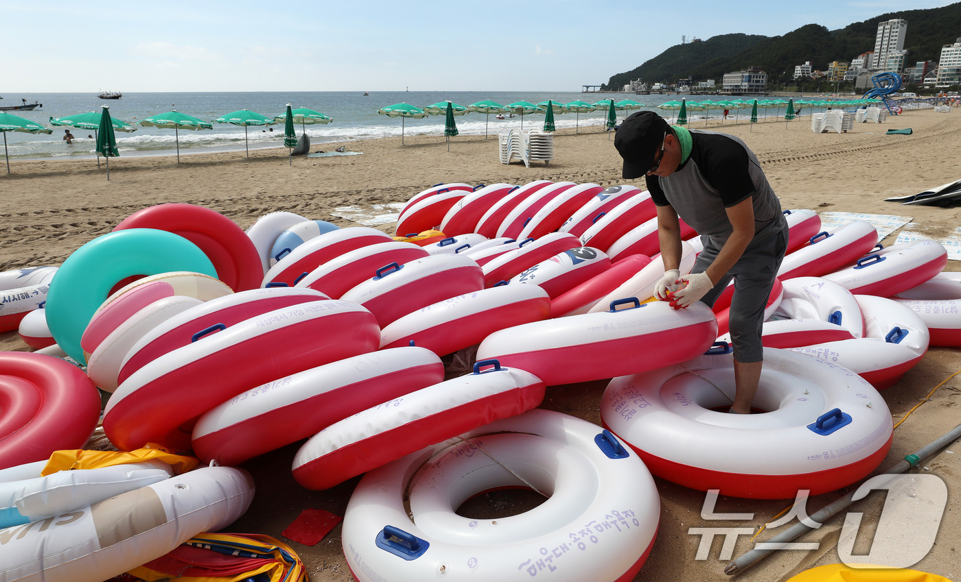 (부산=뉴스1) 윤일지 기자 = 31일 폐장을 앞둔 부산 해운대구 송정해수욕장에서 관계자가 튜브 등 물놀이 용품을 정리하고 있다. 2026.8.31/뉴스1