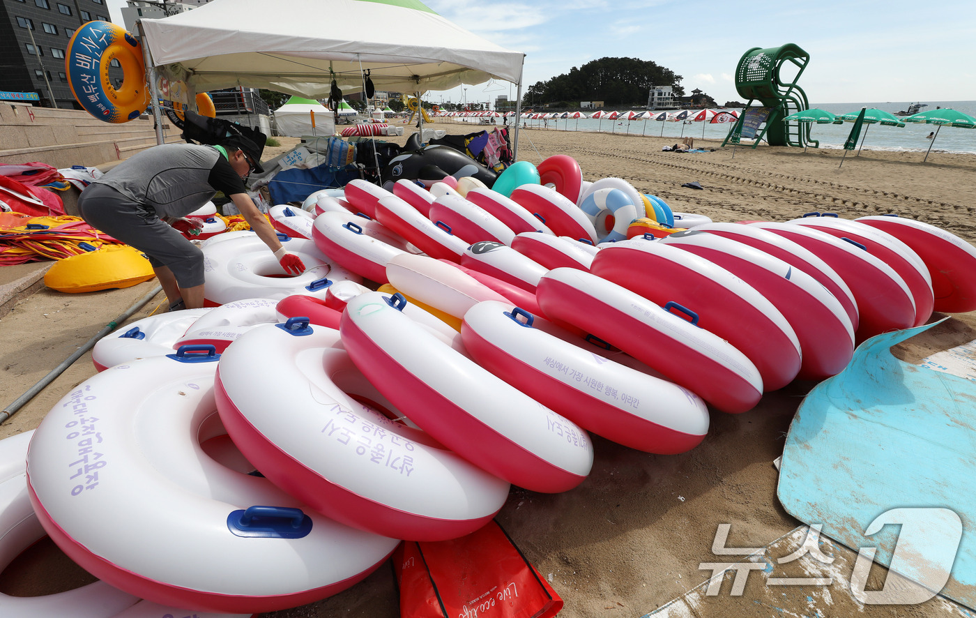 (부산=뉴스1) 윤일지 기자 = 31일 폐장을 앞둔 부산 해운대구 송정해수욕장에서 관계자가 튜브 등 물놀이 용품을 정리하고 있다. 2026.8.31/뉴스1