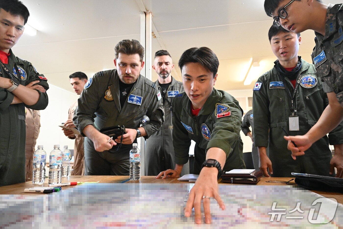 본문 이미지 - 지난달 29일(현지시간) 임무지휘관(Mission Commander) 역할을 맡은 우리 공군의 나형신 대위가 임무계획반(Mission Planning Cell)에서 타국 조종사들과 임무브리핑을 하고 있는 모습. 2026.8.4./ⓒ 뉴스1(공군 제공)