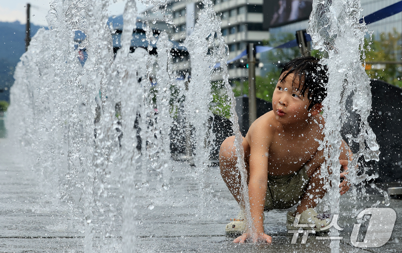 (서울=뉴스1) 이호윤 기자 = 한낮 최고기온 38도 안팎으로 서울 전역에 폭염중대경보가 발효된 4일 서울 종로구 광화문광장 분수대에서 어린이이가 물놀이를 하며 더위를 식히고 있다 …