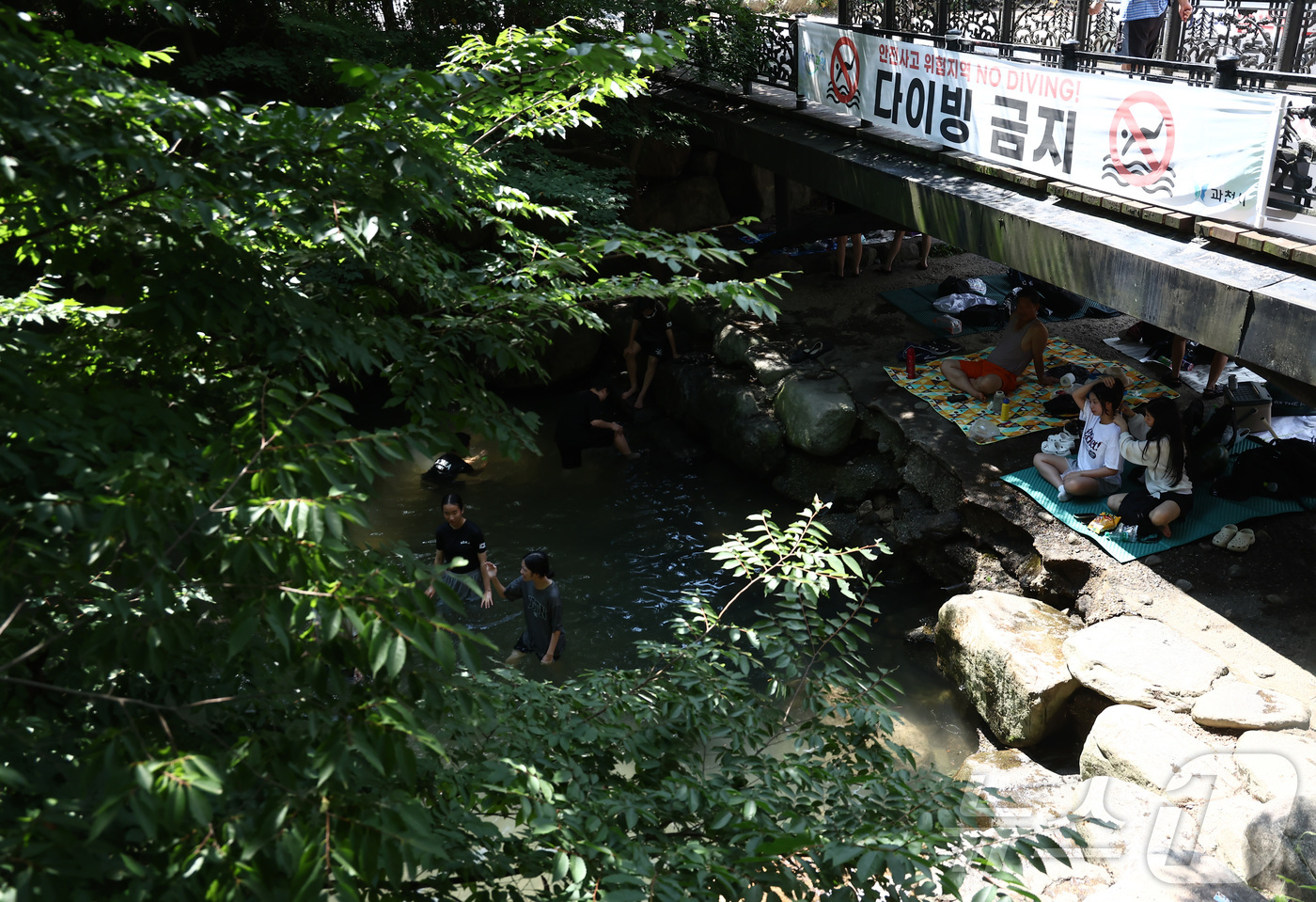 (과천=뉴스1) 김민지 기자 = 연일 극한 폭염이 이어지고 있는 6일 오후 경기 과천시 과천향교 인근 계곡에서 시민들이 햇빛을 피해 다리 아래에서 더위를 식히고 있다. 2026.8 …
