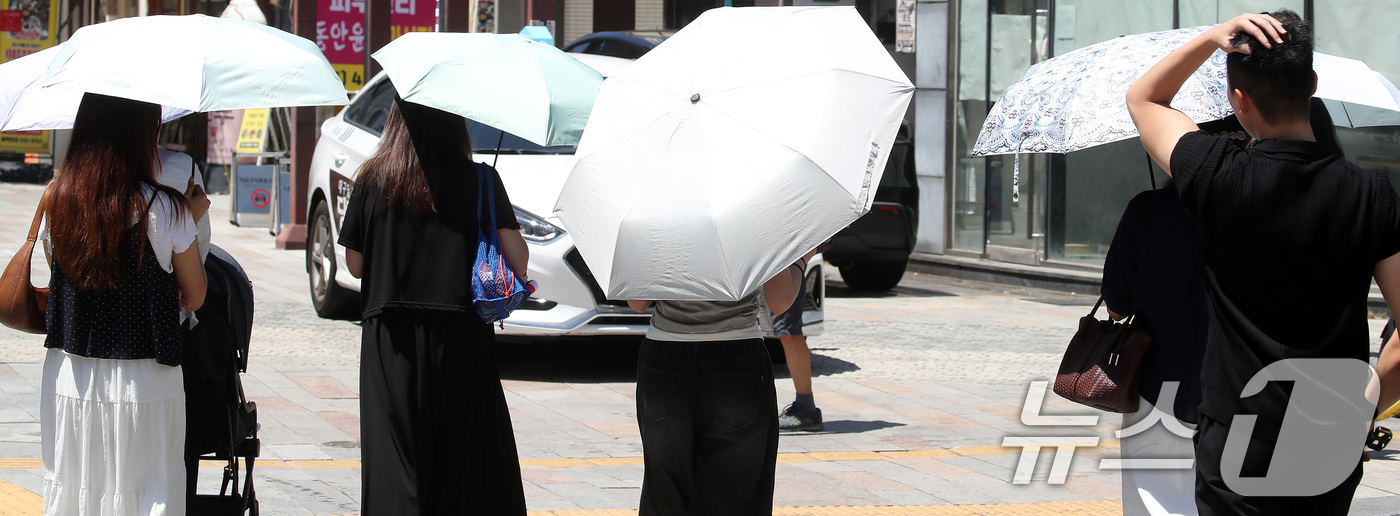 (대구=뉴스1) 공정식 기자 = 가을에 접어든다는 절기 '입추(立秋)'가 하루 앞으로 다가온 6일 폭염이 계속되는 가운데 대구 중구 동성로에서 시민들이 양산으로 뙤약볕을 가린 채 …
