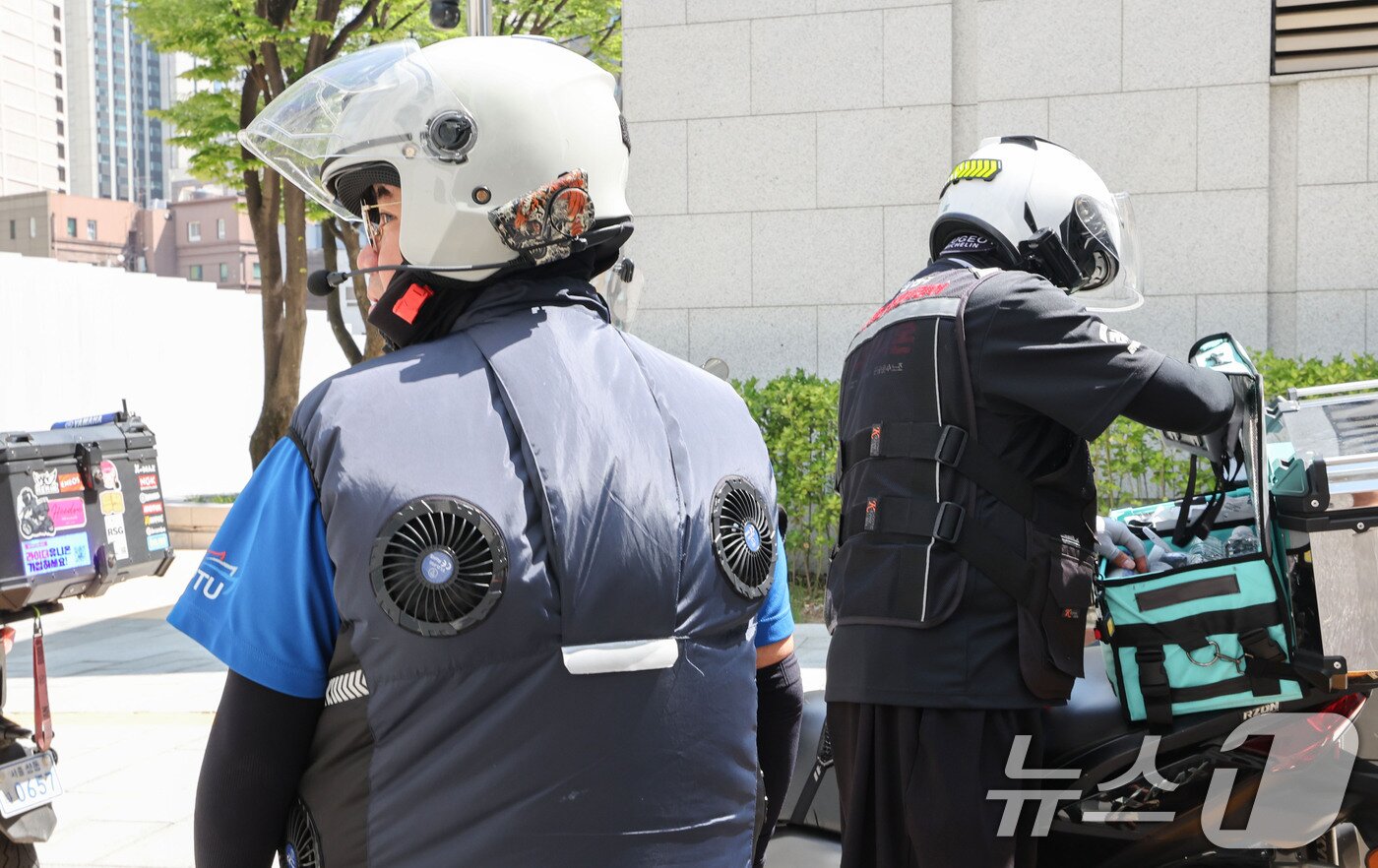 본문 이미지 - 연일 폭염이 이어지는 7일 서울 중구 북창쉼터 앞에서 배달라이더가 선풍기가 달린 냉각 자켓을 입고 휴식을 취하고 있다. 2026.8.7 ⓒ 뉴스1 이종수 기자