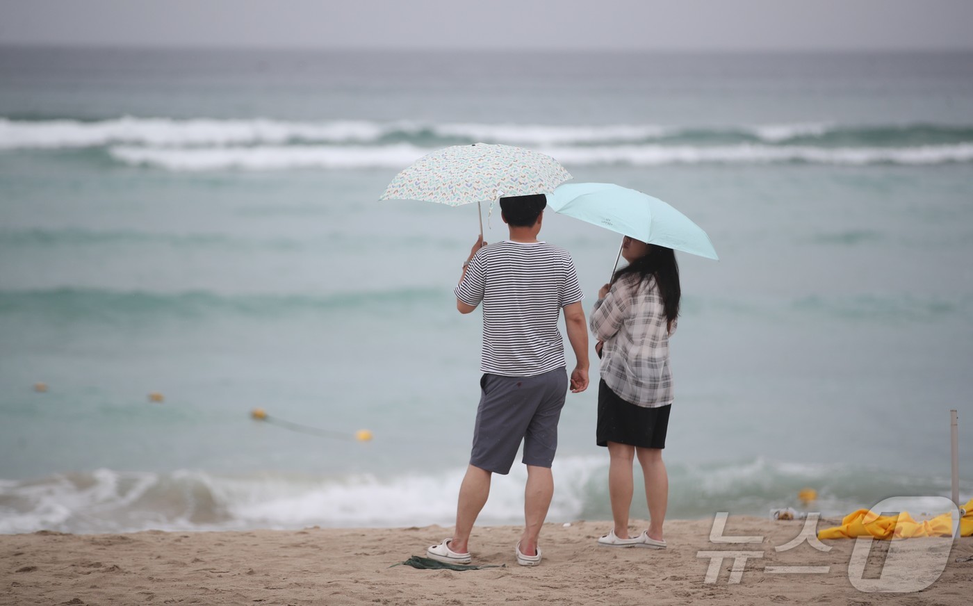 (제주=뉴스1) 강승남 기자 = 제주도 해상에 풍랑주의보가 내려지고, 비가 내리는 9일 오전 제주시 조천읍 함덕해수욕장에서 우산을 쓴 관광객들이 파도가 이는 바다를 바라보고 있다. …