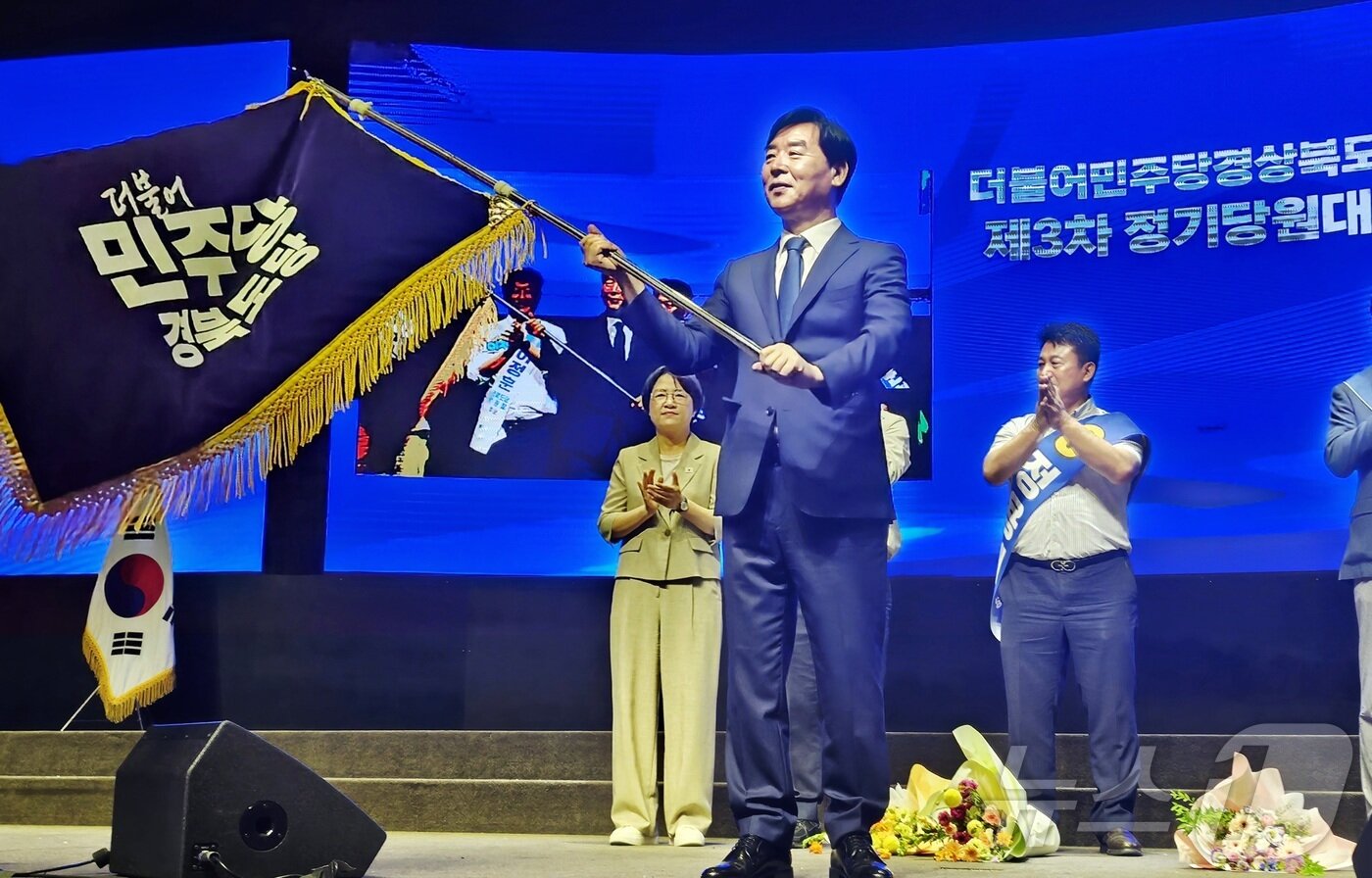 본문 이미지 - 9일 대구 북구 산격동 인터불고 엑스코 호텔에서 열린 더불어민주당 경북도당 정기당원대회에서 차기 도당 위원장으로 선출된 오중기 후보가 민주당 경북도당 당기를 흔들고 있다. ⓒ 뉴스1 남승렬 기자