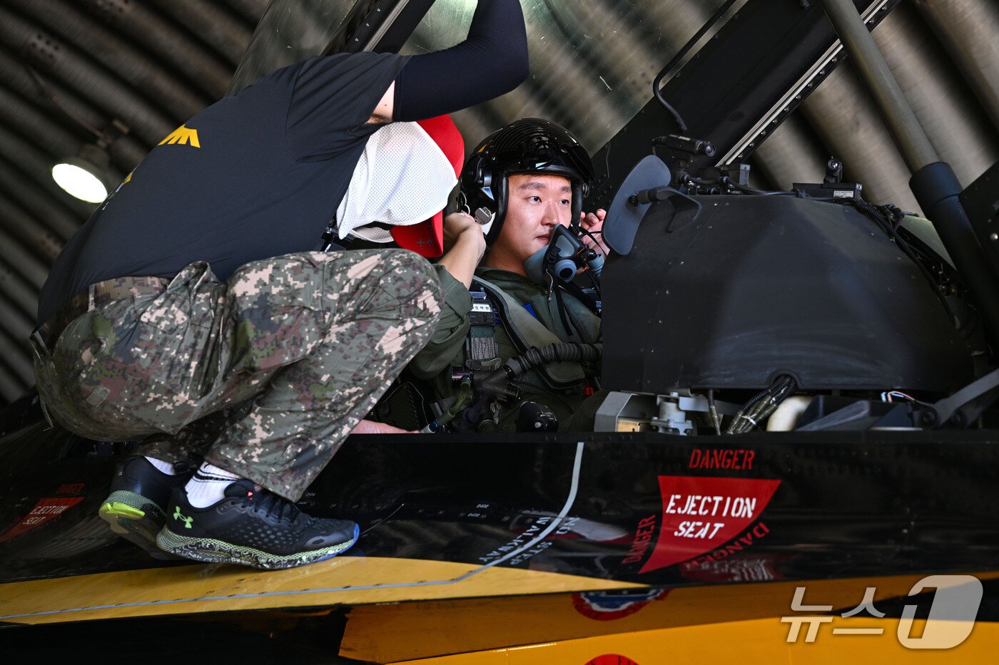 본문 이미지 - 지난 6일 강원도 원주기지에서 공군 특수비행팀 '블랙이글스'가 운용하는 T-50B 후방석에 기자가 탑승해 산소마스크를 착용하는 동안 공군 정비사(왼쪽)가 G-Suit와 좌석의 안전장비 결속 상태를 확인하는 모습. 2026.8.6./ⓒ 뉴스1(공군 제공)