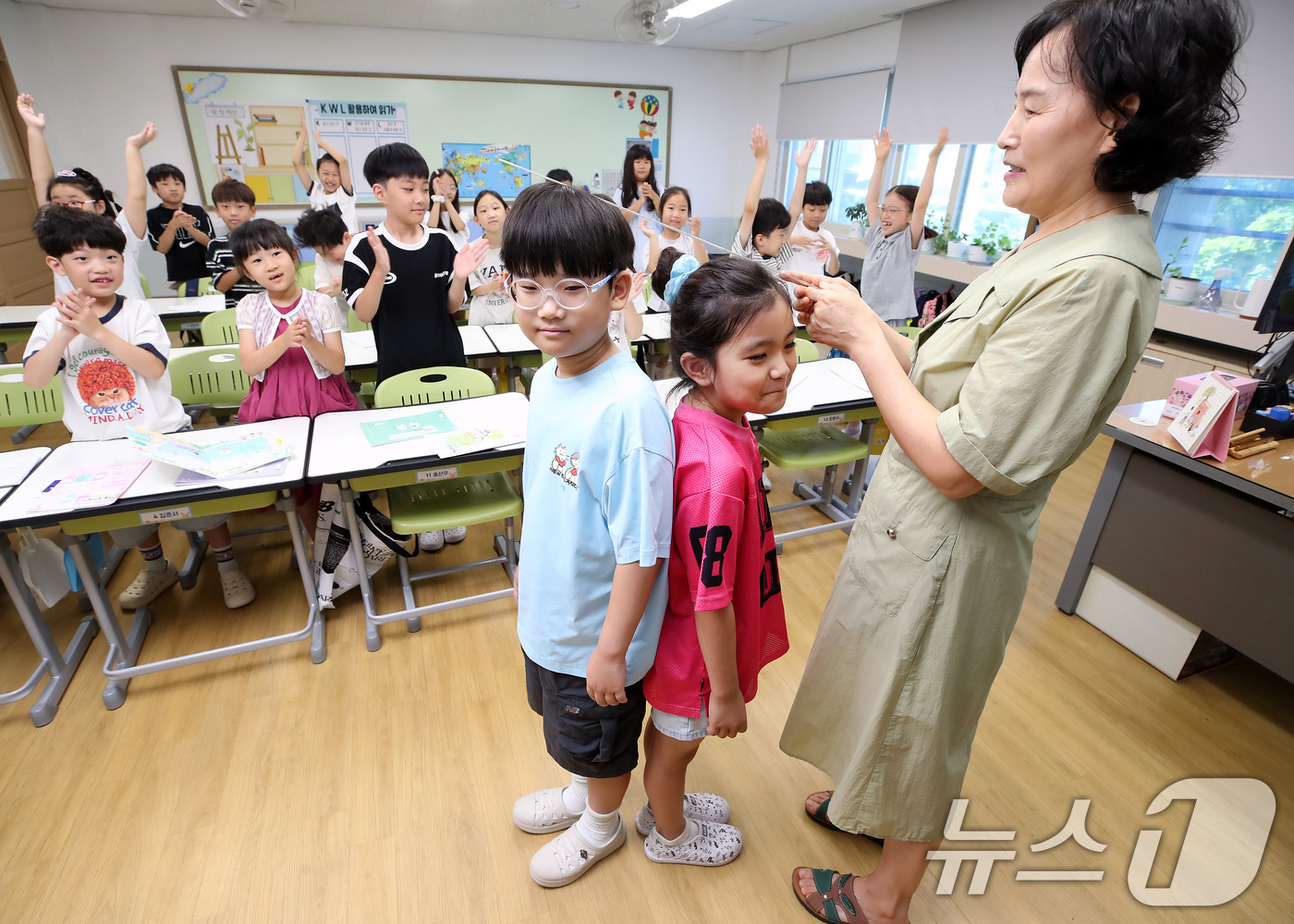 (대구=뉴스1) 공정식 기자 = 대구 지역 초등학교가 여름방학을 마치고 개학한 1일 대구 서구 평리동 이현초 2학년 학생들이 담임 선생님과 키를 재고 있다. 2026.9.1/뉴스1 …