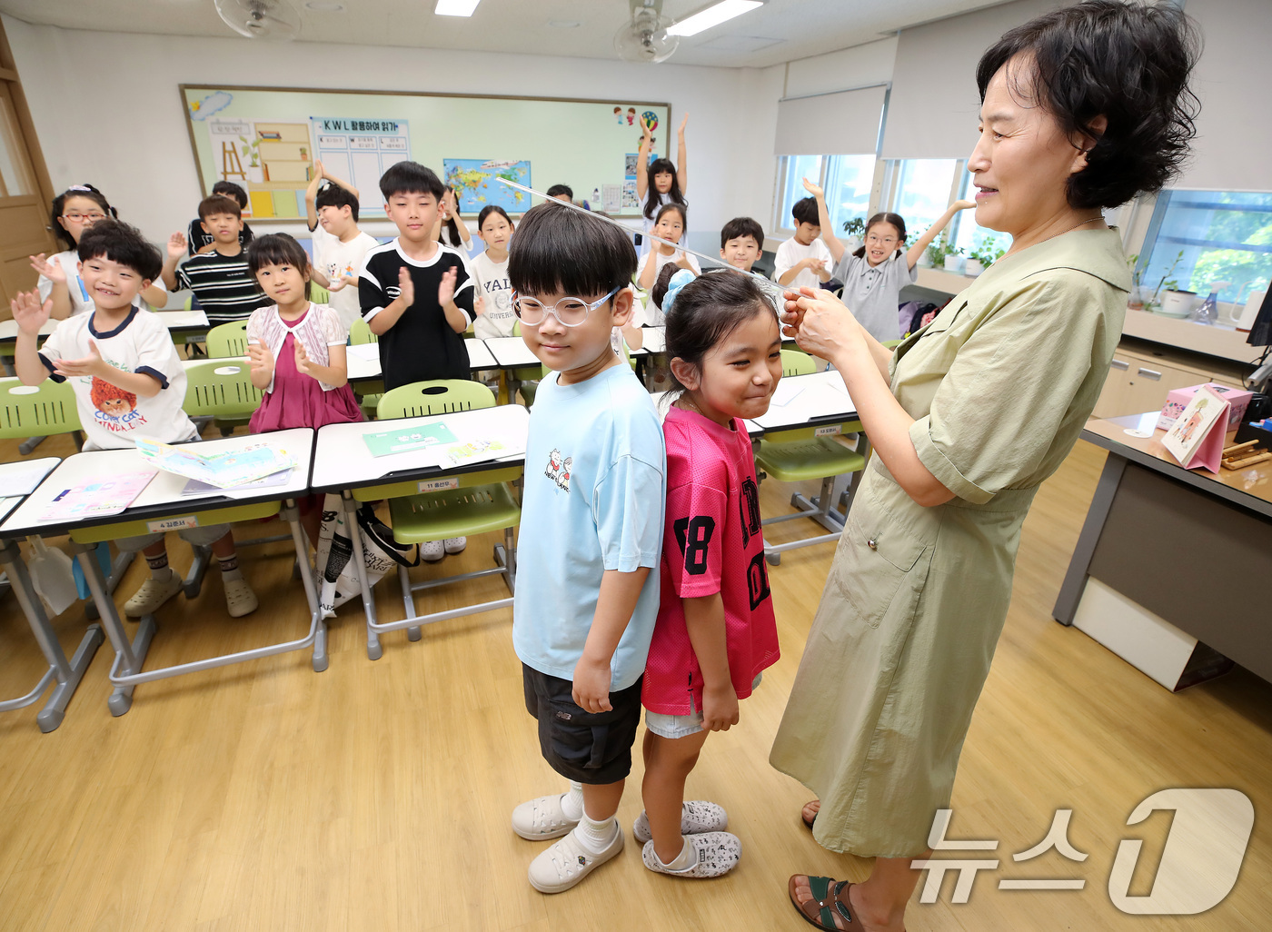 (대구=뉴스1) 공정식 기자 = 대구 지역 초등학교가 여름방학을 마치고 개학한 1일 대구 서구 평리동 이현초 2학년 학생들이 담임 선생님과 키를 재고 있다. 2026.9.1/뉴스1 …