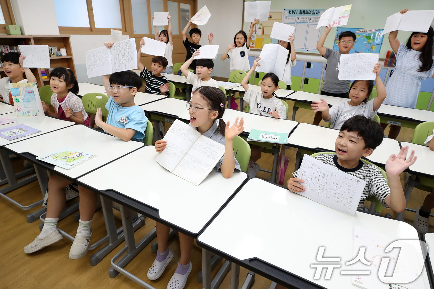 (대구=뉴스1) 공정식 기자 = 대구 지역 초등학교가 여름방학을 마치고 개학한 1일 대구 서구 평리동 이현초 2학년 학생들이 방학 과제물을 들어 보이며 담임 선생님과 인사하고 있다 …