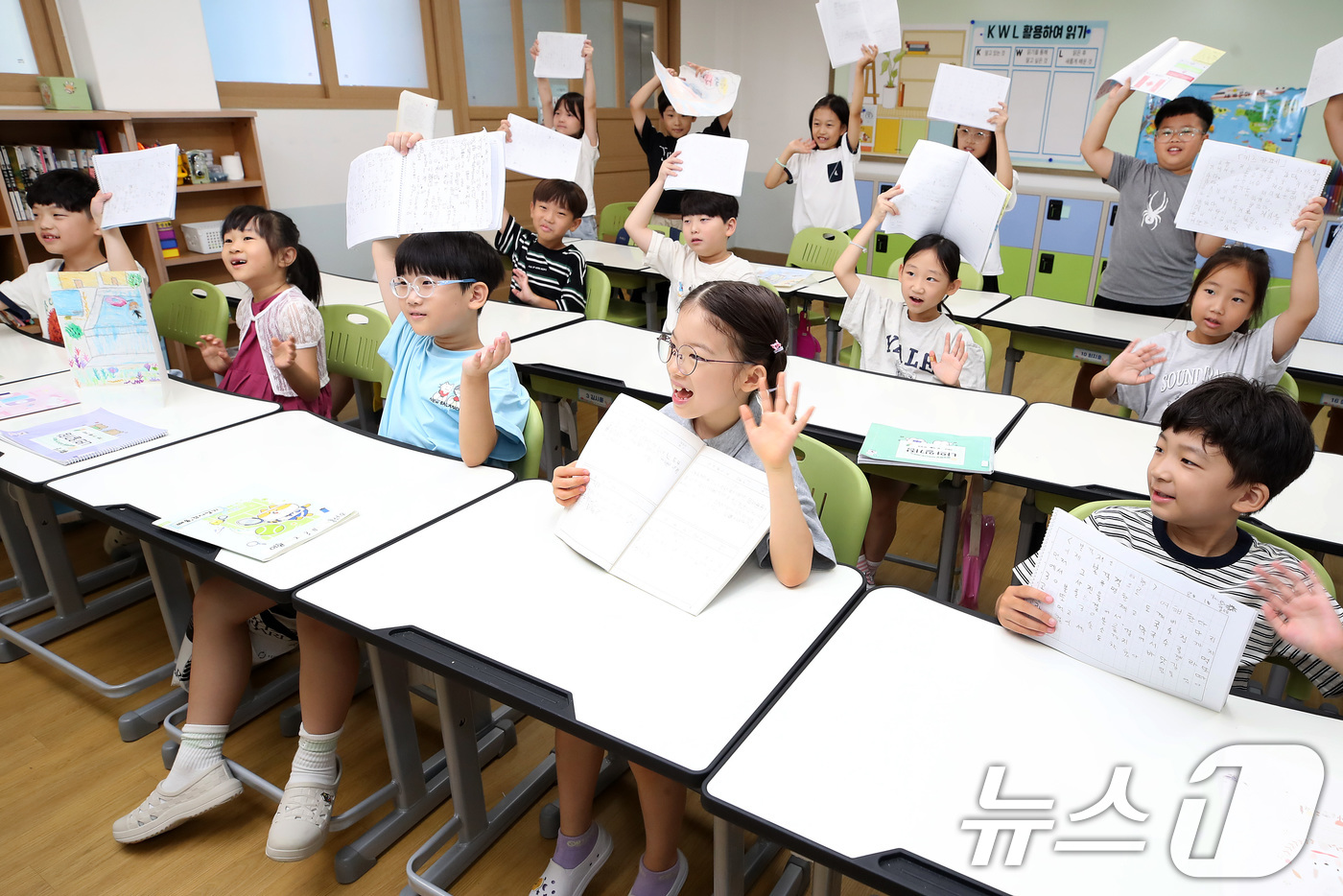 (대구=뉴스1) 공정식 기자 = 대구 지역 초등학교가 여름방학을 마치고 개학한 1일 대구 서구 평리동 이현초 2학년 학생들이 방학 과제물을 들어 보이며 담임 선생님과 인사하고 있다 …