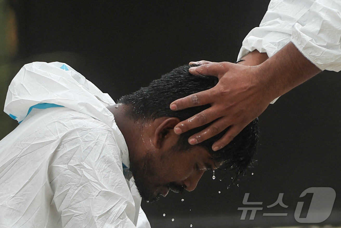 (누와코트 로이터=뉴스1) 이동건 수습기자 = 1일(현지시간) 네팔 누와코트 지역 트리슐리의 마이탈리 막사에서 한 의료진이 홍수와 산사태 희생자들의 시신 인계 작업을 마친 뒤 휴식 …