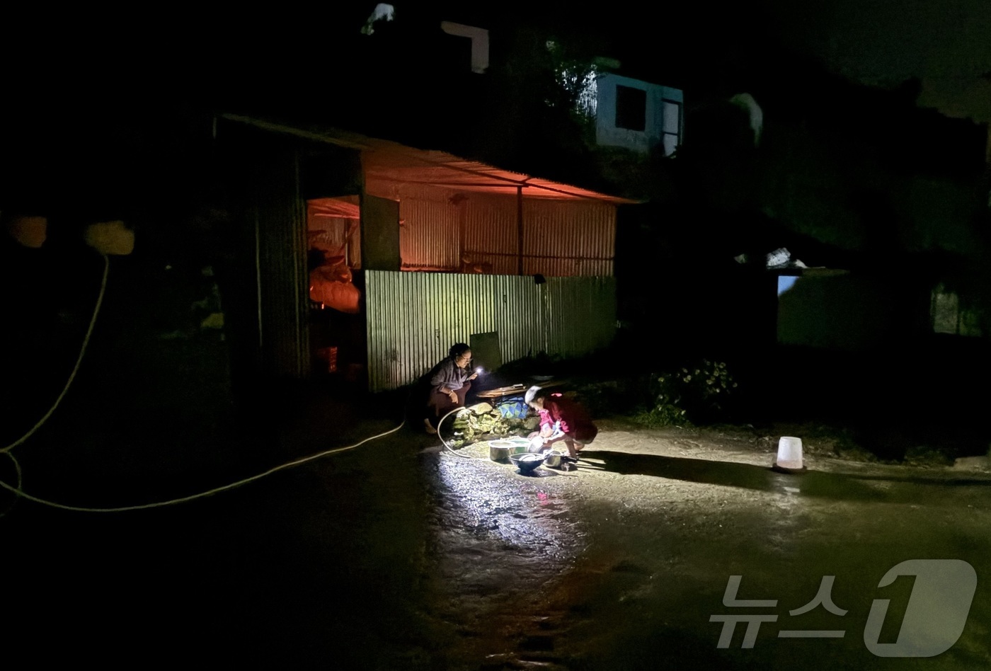(라수와(네팔)=뉴스1) 구윤성 기자 = 지난 31일(현지시간) 정부합동신속대응팀이 머물고 있는 네팔 라수와 지역 램체에서 마을 주민들이 휴대폰 불빛에 의지해 설거지를 하고 있다. …