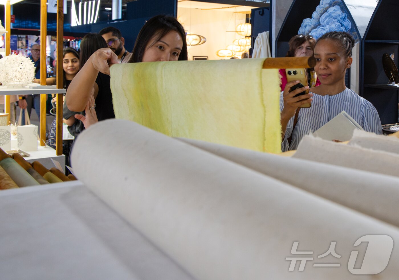 본문 이미지 - 10일(현지시간) 프랑스 파리 근교 노르 빌팽트 전시장에서 열린 '메종&오브제'(Maison&Objet) 한지관에서 관람객이 펼쳐진 노란 한지를 살펴보고 있다. 한국공예·디자인문화진흥원이 운영하는 한지관에는 국내 7개 기업이 참여해 한지 원지와 생활용품 등을 선보인다. 박람회는 오는 14일까지 열린다. 2026.9.11 ⓒ 뉴스1 이준성 특파원