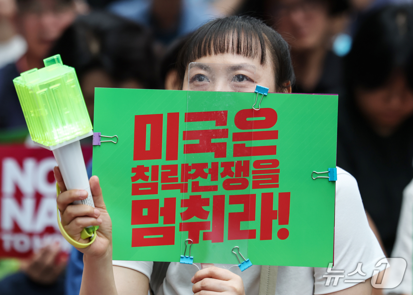 (서울=뉴스1) 김민지 기자 = 12일 서울 종로구 광화문 일대에서 열린 미국은 침략전쟁 중단하라! 정부는 호르무즈파병 단호히 거부하라! 시민대행진에서 한 시민이 손피켓을 들고 파 …