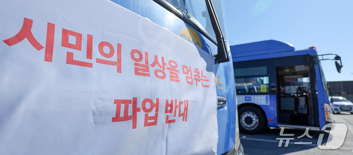 본문 이미지 - 서울 시내버스 노조의 파업 예고일을 하루 앞둔 15일 서울 시내 한 공영차고지에 주차된 버스 전면에 파업 반대 현수막이 걸려 있다. 2026.9.15 ⓒ 뉴스1 김성진 기자