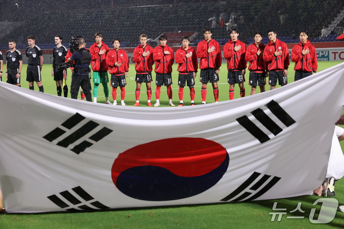 본문 이미지 - 15일 오후 일본 나고야 미즈호 파크 럭비 필드에서 열린 2026 아이치·나고야 아시안게임 남자축구 D조 예선 대한민국과 카타르의 경기에서 대한민국 대표팀이 국민의례를 하고 있다. 2026.9.15 ⓒ 뉴스1 안은나 기자