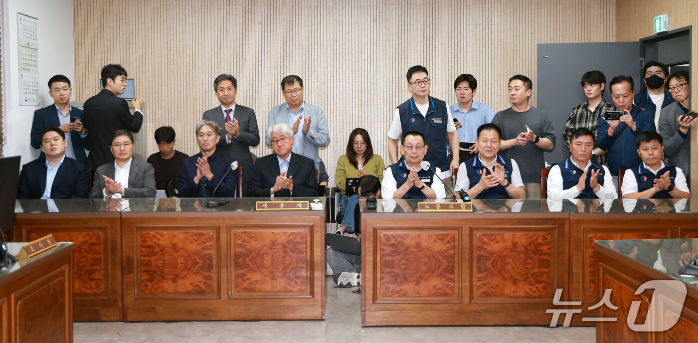 본문 이미지 - 김정환 서울시버스사업조합 이사장과 박점곤 서울시버스노동조합 위원장을 비롯한 참석자들이 16일 서울 영등포구 서울지방노동위원회에서 열린 특별조정위원회 2차 사후 조정 회의에서 서울 시내버스 노사 협상에 극적으로 합의한 뒤 박수를 치고 있다. 2026.9.16 ⓒ 뉴스1 이호윤 기자