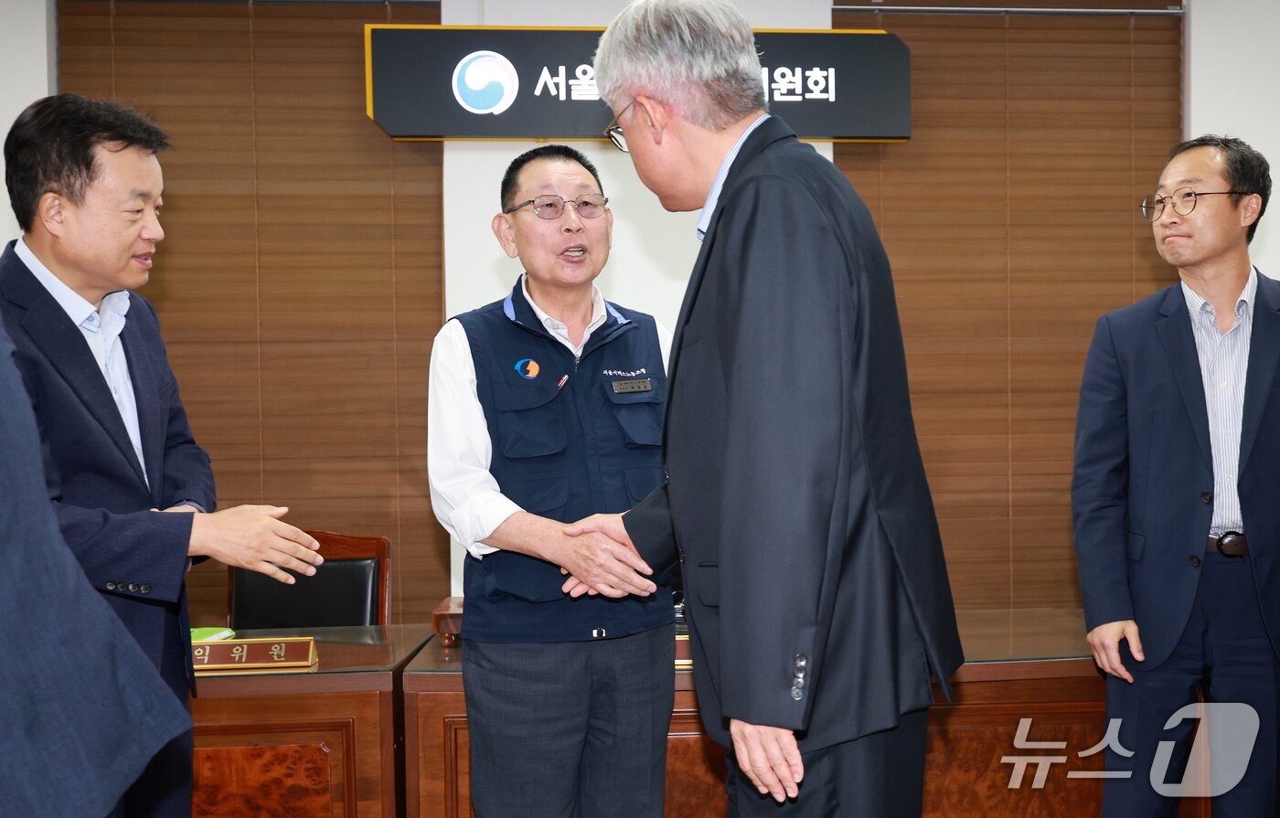 본문 이미지 - 김정환 서울시버스사업조합 이사장(오른쪽)과 박점곤 서울시버스노동조합 위원장이 16일 서울 영등포구 서울지방노동위원회에서 열린 특별조정위원회 2차 사후 조정 회의에서 서울 시내버스 노사 협상에 극적으로 합의한 뒤 악수를 나누고 있다. 2026.9.16 ⓒ 뉴스1 이호윤 기자