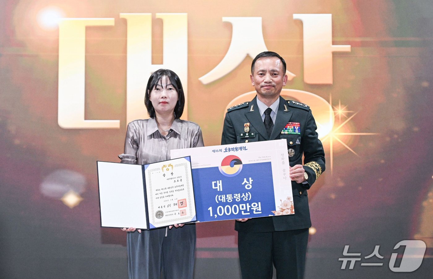 (서울=뉴스1) 김진환 기자 = 최장식 육군참모차장(중장)이 16일 서울 용산구 전쟁기념관에서 열린 제16회 호국미술대전 개막식에서 대상을 수상한 조모금 씨에게 대통령상을 전달하고 …