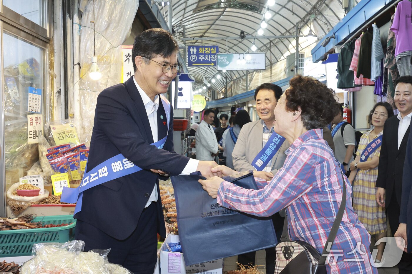 본문 이미지 - 17일 전주 모래내시장을 방문한 이원택 전북도지사가 한 시민에게 장바구니를 나눠주고 반갑게 인사를 건네고 있다.(전북도 제공. 재판매 및 DB 금지)/뉴스1 