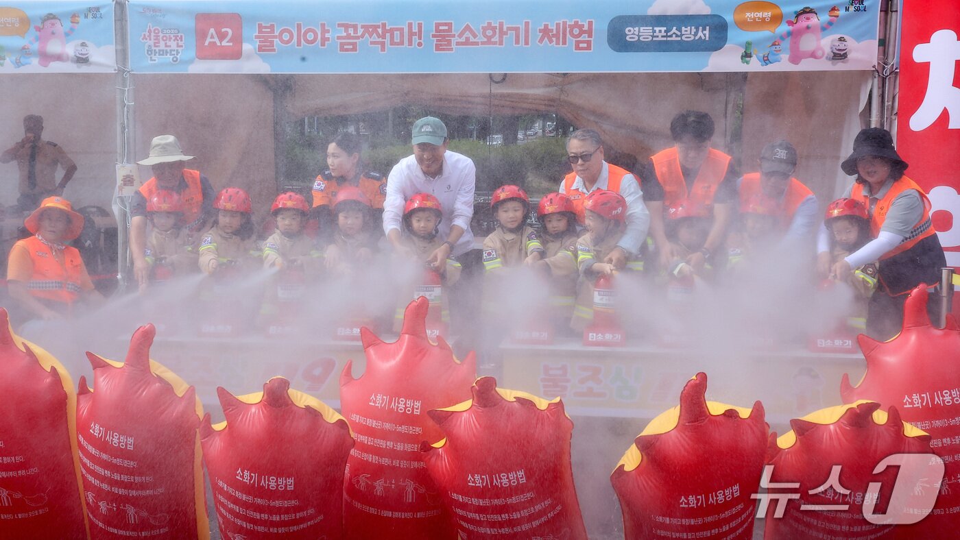 본문 이미지 - 오세훈 서울시장이 17일 서울 영등포구 여의도공원 문화의마당에서 열린 2026 서울안전한마당 안전다짐식에서 어린이들과 물소화기 체험을 하고 있다. 2026.9.17 ⓒ 뉴스1 김성진 기자