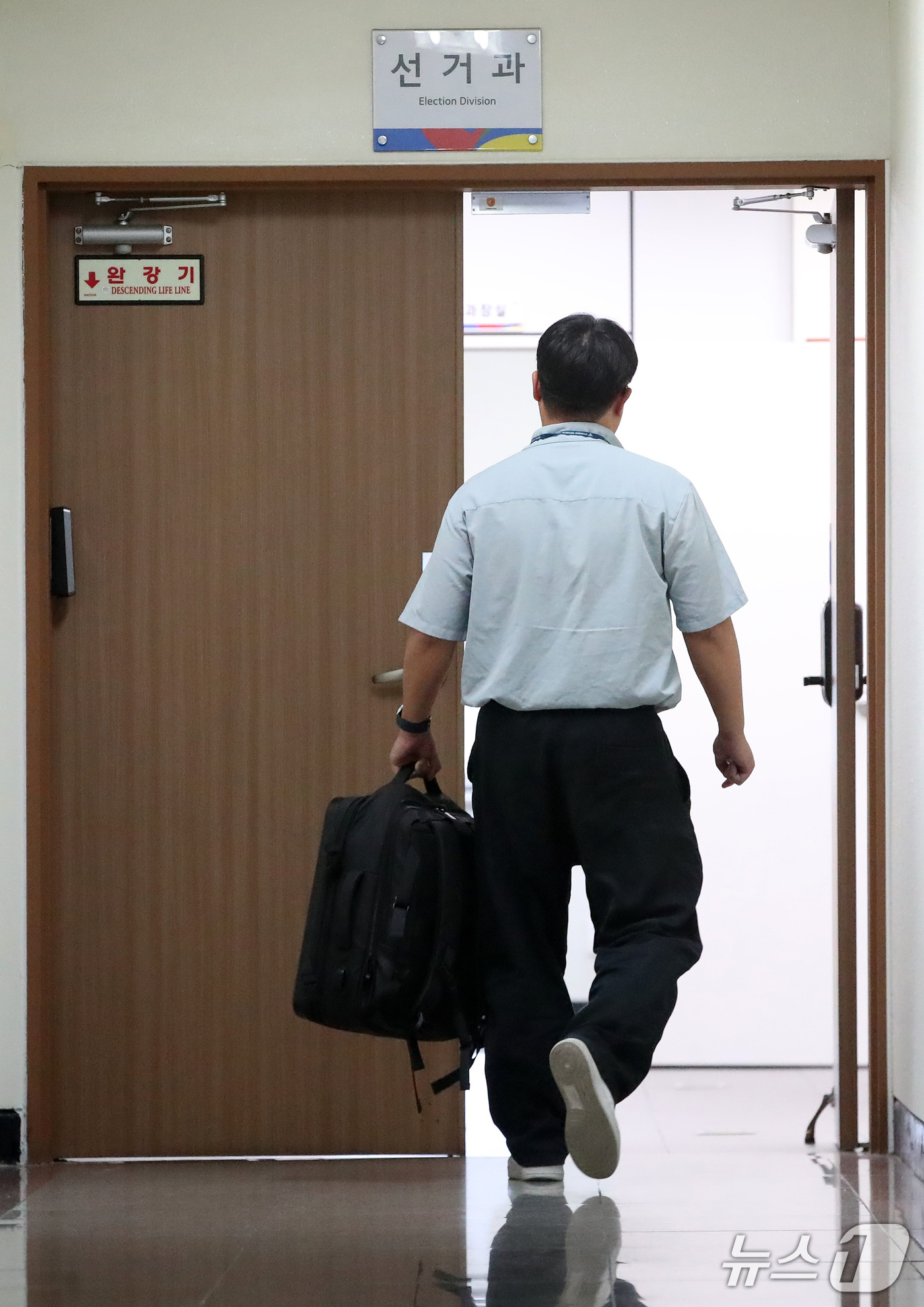 (대구=뉴스1) 공정식 기자 = 6·3 지방선거 투표용지 부족 사태를 조사하는 특검팀 관계자가 17일 오후 압수수색 장비 가방을 들고 대구시선거관리위원회 선거과 사무실로 들어가고 …