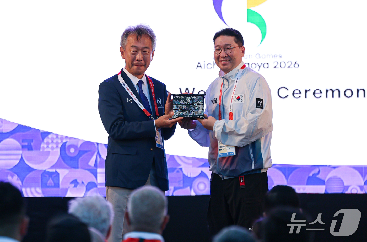(나고야=뉴스1) 김도우 기자 = 이상현 대한민국 선수단장 17일 일본 나고야 2026 아이치·나고야 아시안게임 선수촌에서 열린 입촌식에서 선물교환을 하고 기념촬영을 하고 있다. …