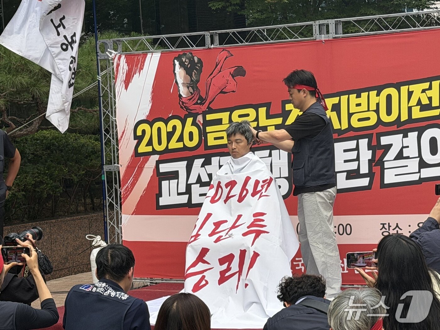 본문 이미지 - 금융노조가 18일 서울 중구 은행회관 앞에서 개최한 '2026 금융노조 지방이전 저지 및 교섭파행 규탄 결의대회'에서 윤석구 위원장의 삭발식을 진행하고 있다.