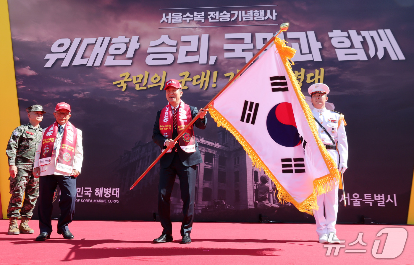 (서울=뉴스1) 박세연 기자 = 오세훈 서울시장이 19일 중구 서울광장에서 열린 2026년 서울수복 전승기념행사에서 참전용사에게 태극기를 받아 흔들고 있다. 2026.9.19/뉴스 …