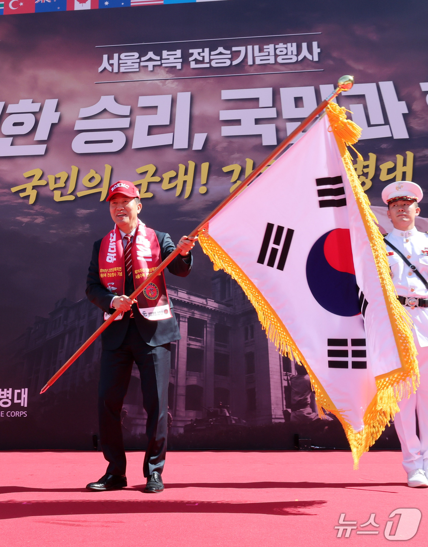 (서울=뉴스1) 박세연 기자 = 오세훈 서울시장이 19일 중구 서울광장에서 열린 2026년 서울수복 전승기념행사에서 참전용사에게 태극기를 받아 흔들고 있다. 2026.9.19/뉴스 …