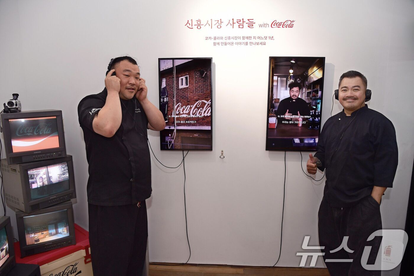 (서울=뉴스1) = 지난 1일 서울 용산구 신흥시장에서 열린 전시 '신흥시장 사람들 위드 코카-콜라'에서 상인들이 자신의 인터뷰 영상을 감상하고 있다.이번 전시에서는 신흥시장 상인 …