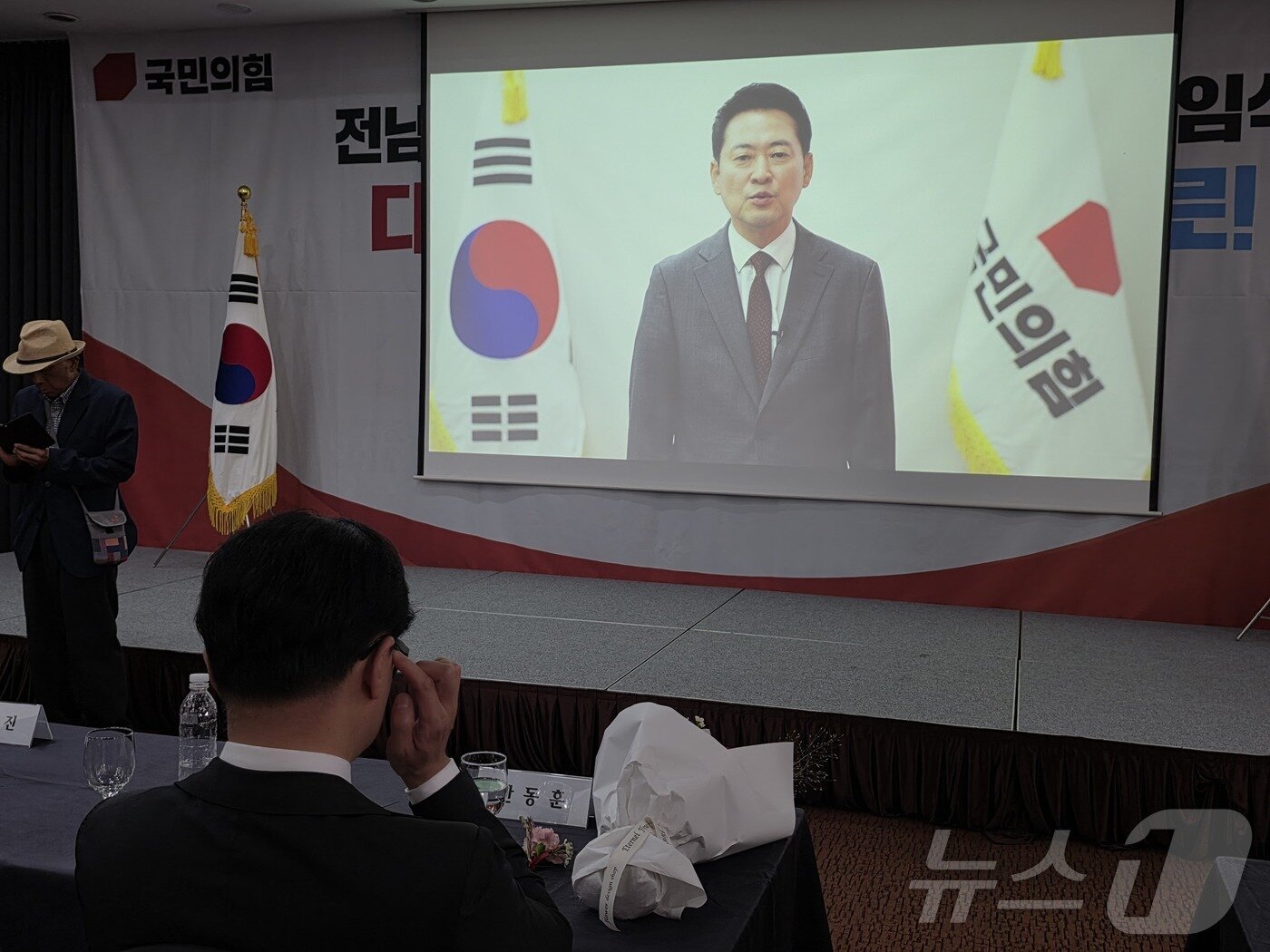 본문 이미지 - 2일 김화진 국민의힘 전남광주통합특별시당위원장의 취임식에 참석한 한동훈 무소속 국회의원(부산 북구갑)이 장동혁 국민의힘 대표의 영상 축사를 보고 있다. 2026.9.2 ⓒ 뉴스1 서충섭 기자