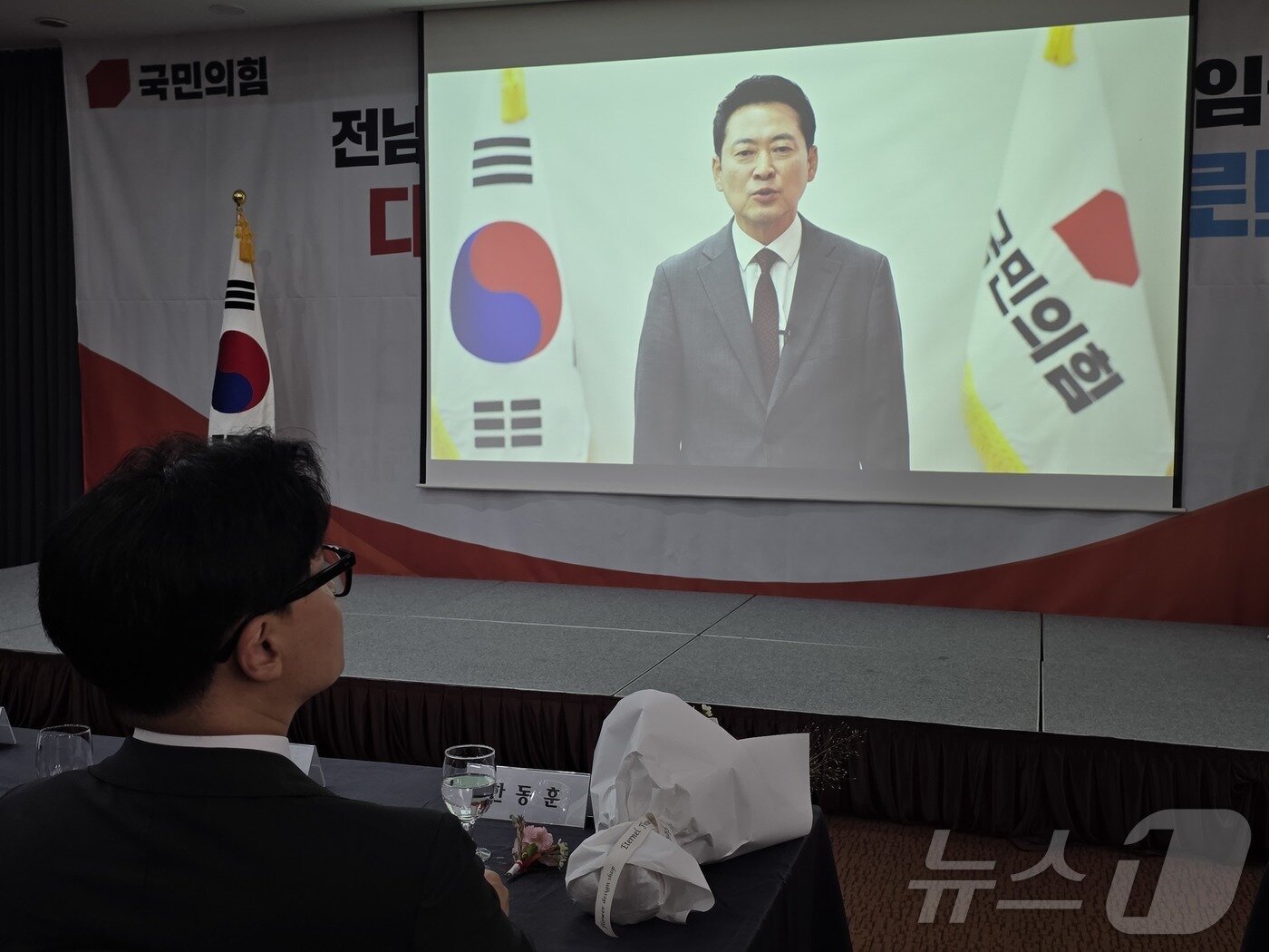 본문 이미지 - 2일 김화진 국민의힘 전남광주통합특별시당위원장의 취임식에 참석한 한동훈 무소속 국회의원(부산 북구갑)이 장동혁 국민의힘 대표의 영상 축사를 보고 있다. ⓒ 뉴스1 서충섭 기자