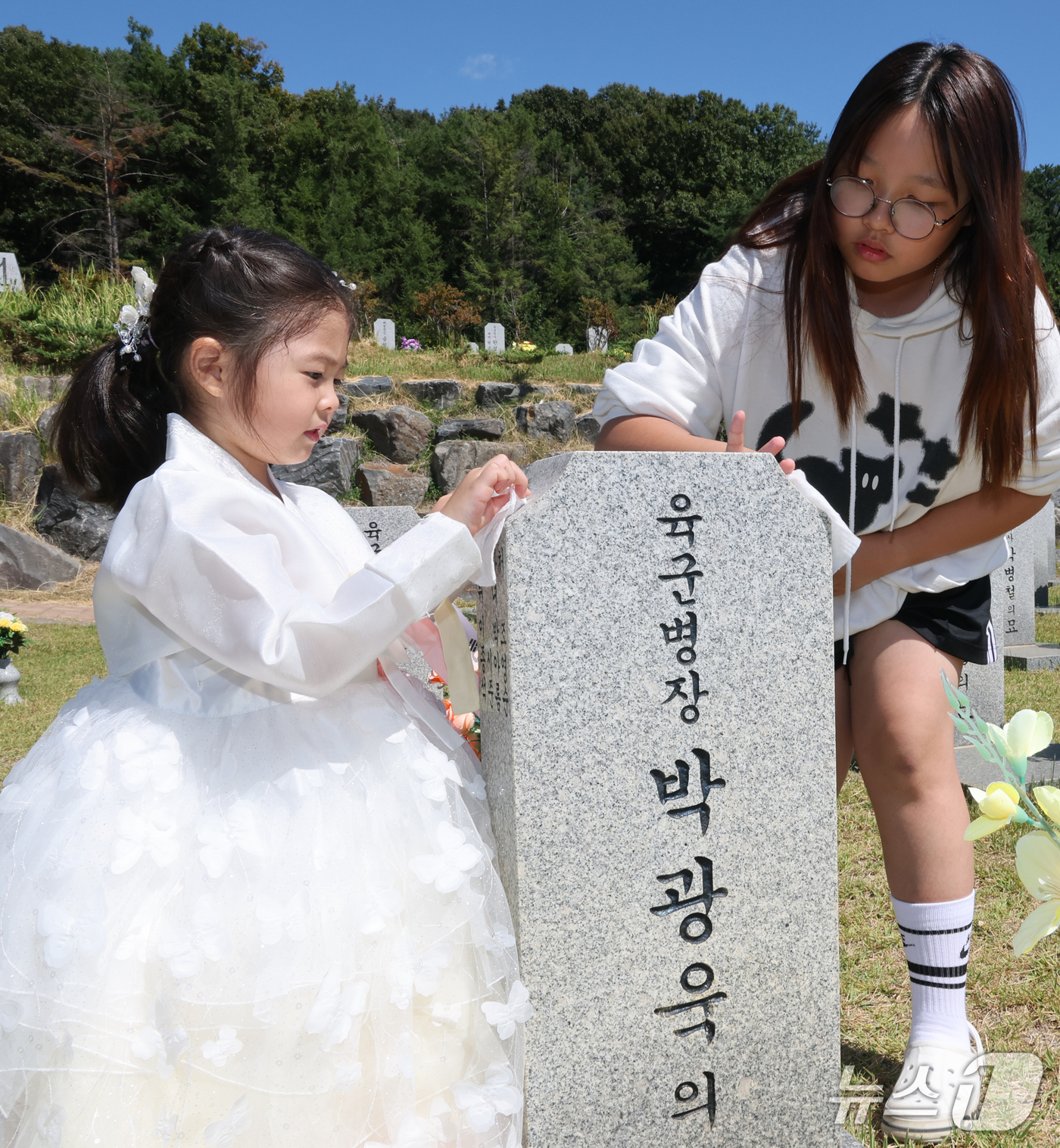 (대전뉴스1) 김기태 기자 = 추석 명절을 앞둔 20일 대전 유성구 국립대전현충원 모역에서 한복을 곱게 차려입은 어린이가 할아버지 묘비를 닦고 있다. 2026.9.20/뉴스1