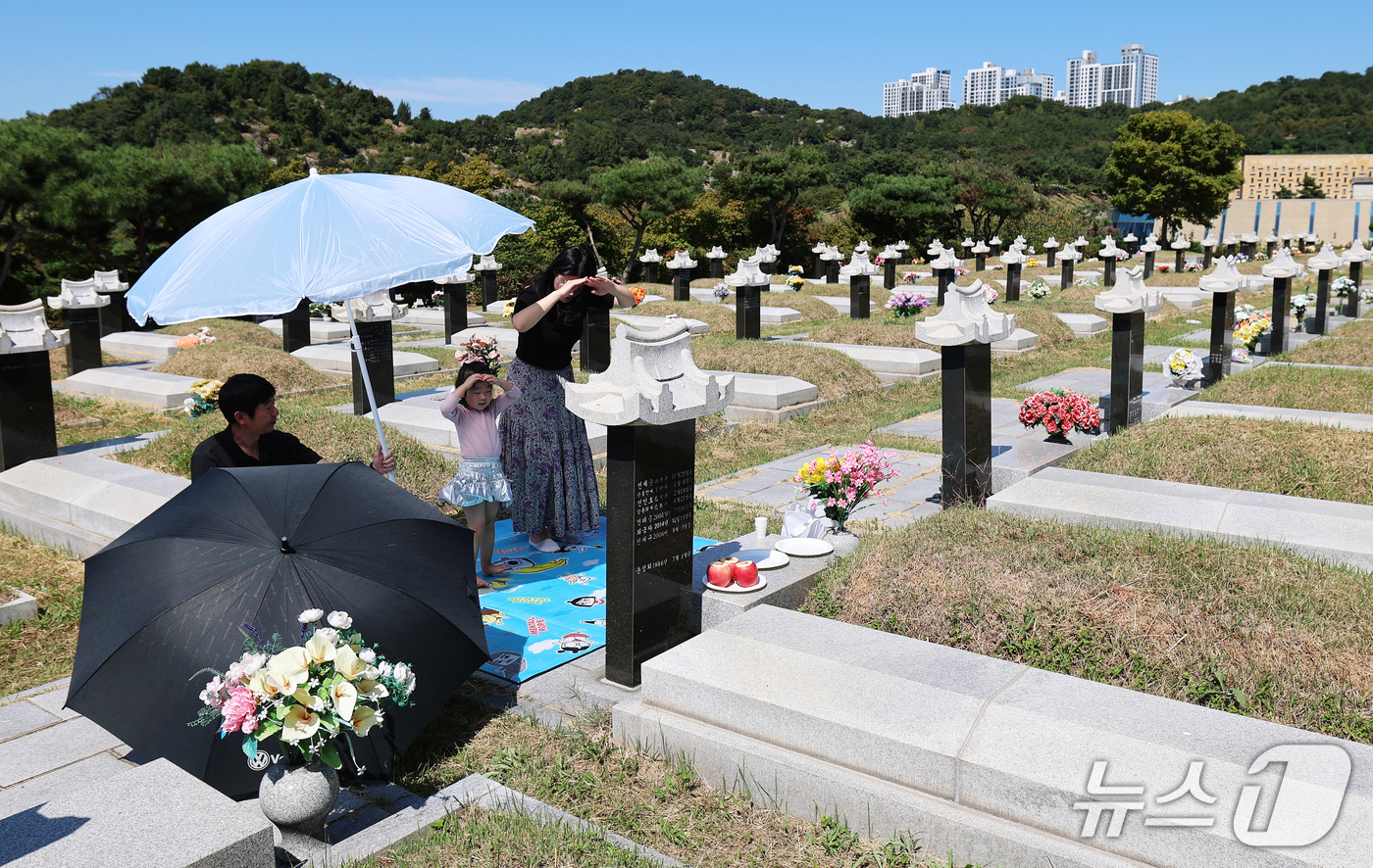 (인천=뉴스1) 오대일 기자 = 추석 명절을 앞둔 20일 인천 부평구 인천가족공원에서 부모와 함께 이른 성묘에 나선 어린이가 할머니 묘에 절을 올리고 있다. 2026.9.20/뉴스 …