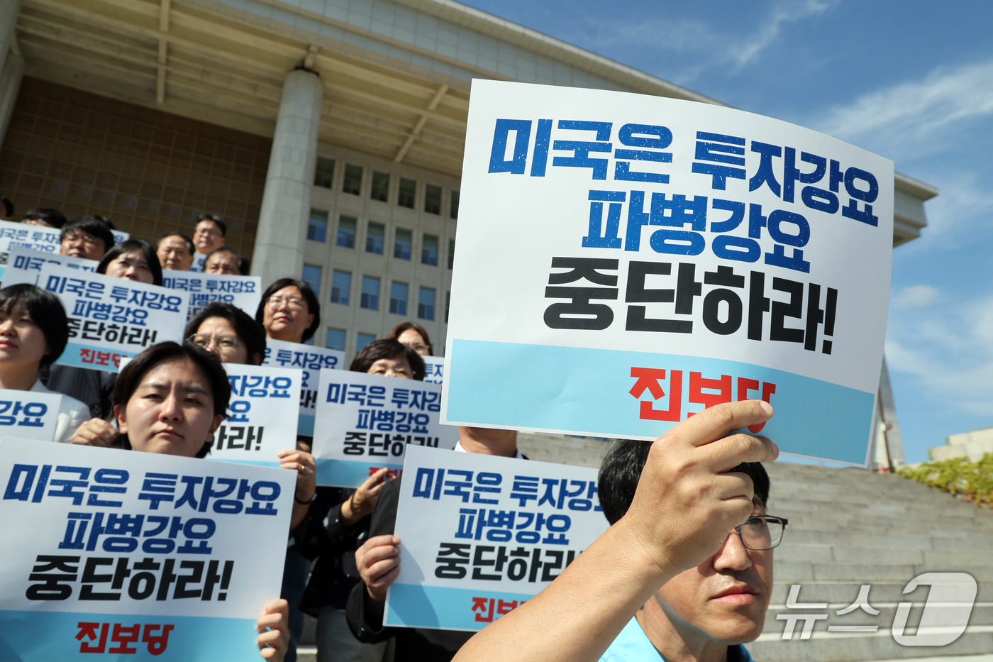 (서울=뉴스1) 황기선 기자 = 진보당 당원들이 20일 오후 서울 여의도 국회 본관 계단에서 열린 '미국의 대미투자·파병 강요 중단 촉구 진보당 중앙위원 기자회견'에서 손팻말을 들 …