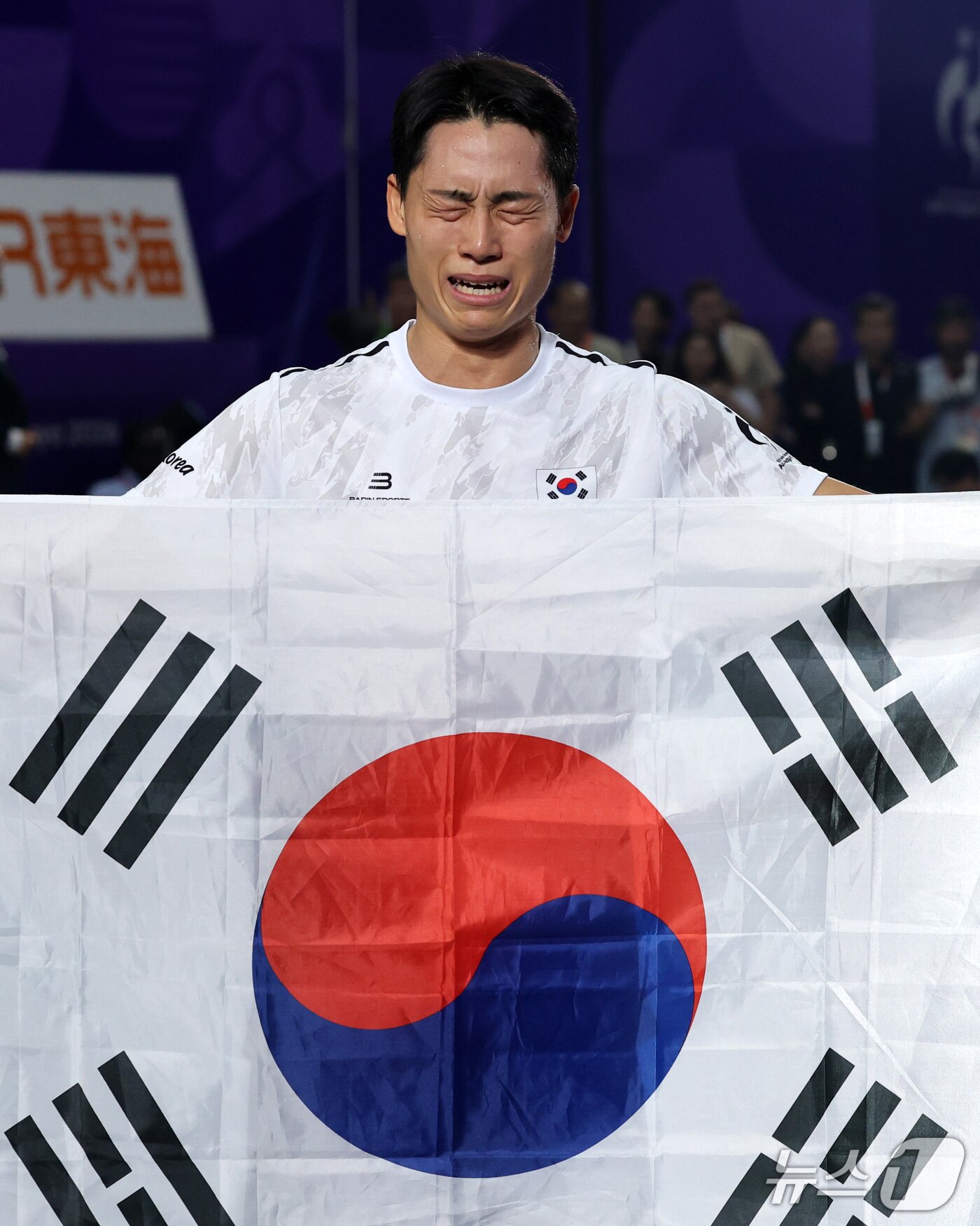 본문 이미지 - 한국 테크볼 사상 첫 국제종합스포츠대회 메달리스트가 된 이준석이 20일 일본 나고야 히가시 스포츠센터에서 열린 2026 아이치·나고야 아시안게임 테크볼 남자 단식 결승전에서 금메달을 따낸 후 태극기를 들고 눈물을 흘리고 있다. 2026.9.20 ⓒ 뉴스1 안은나 기자