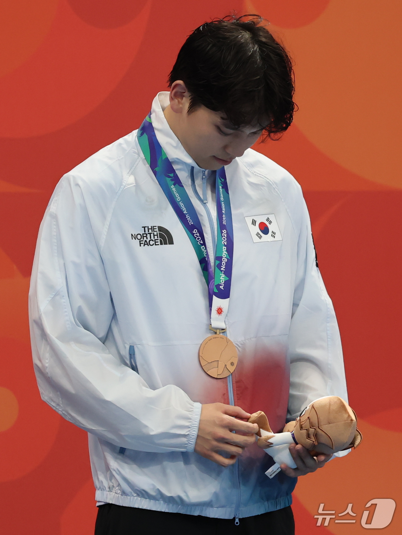 (도쿄=뉴스1) 김민지 기자 = 20일 도쿄 아쿠아틱스 센터에서 열린 2026 아이치·나고야 아시안게임 수영 남자 배영 100m 시상식에서 동메달을 획득한 이주호가 마스코트 인형을 …