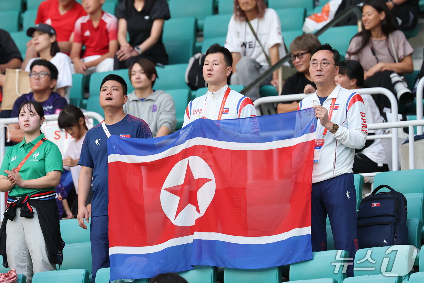 본문 이미지 - 21일 일본 시즈오카 스타디움 에코파에서 열린 2026 아이치·나고야 아시안게임 여자축구 조별예선 F조 대한민국과 북한의 경기에서 북한 응원단이 인공기를 들고 응원을 하고 있다. 2026.9.21 ⓒ 뉴스1 안은나 기자