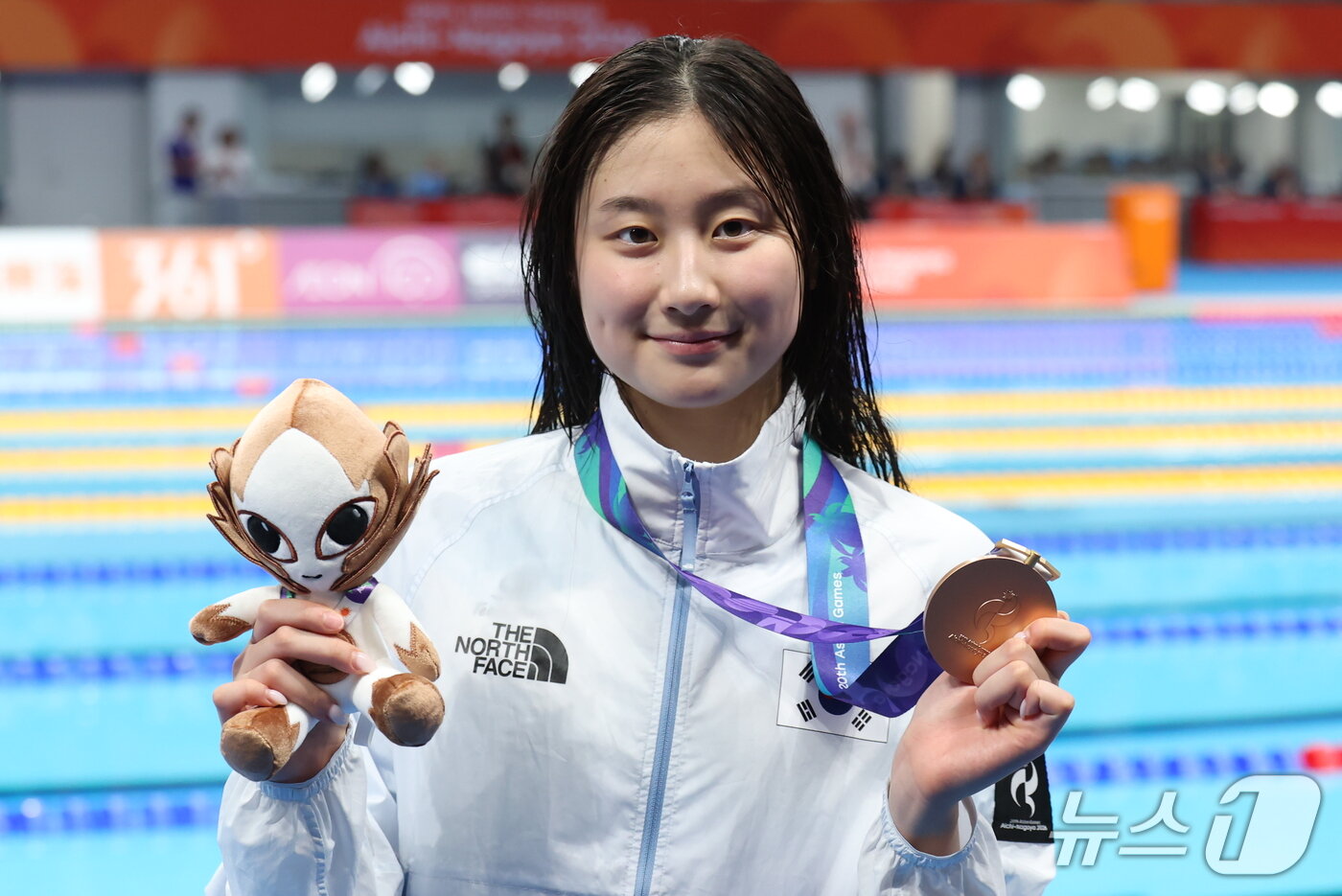 본문 이미지 - 21일 도쿄 아쿠아틱스 센터에서 열린 2026 아이치·나고야 아시안게임 여자 50m 배영 결승전에서 동메달을 획득한 김승원이 시상대에 올라 동메달을 들어 보이고 있다. 2026.9.21 ⓒ 뉴스1 김민지 기자