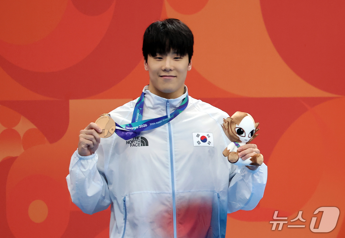 (도쿄=뉴스1) 김민지 기자 = 21일 도쿄 아쿠아틱스 센터에서 열린 2026 아이치·나고야 아시안게임 남자 50m 자유형 결승전에서 동메달을 획득한 지유찬이 시상대에서 메달을 들 …