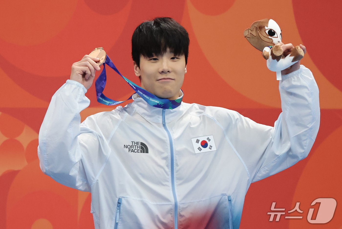 (도쿄=뉴스1) 김민지 기자 = 21일 도쿄 아쿠아틱스 센터에서 열린 2026 아이치·나고야 아시안게임 남자 50m 자유형 결승전에서 동메달을 획득한 지유찬이 시상대에서 메달을 들 …