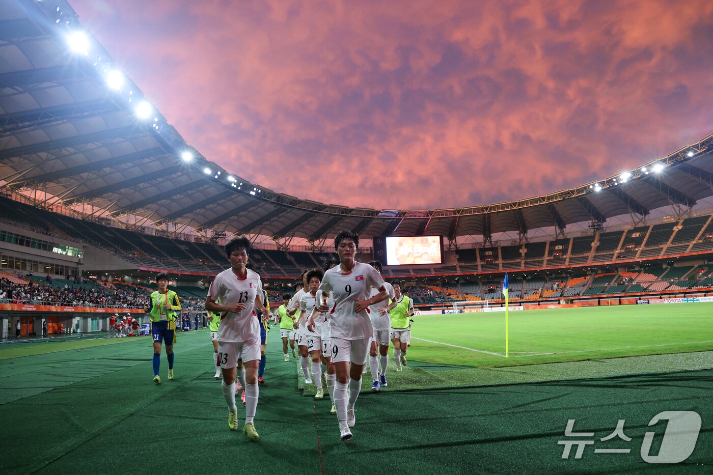 본문 이미지 - 21일 일본 시즈오카 스타디움 에코파에서 열린 2026 아이치·나고야 아시안게임 여자축구 조별예선 F조 대한민국과 북한의 경기를 무승부로 마친 북한 선수들이 응원단을 향해 달려가고 있다. 2026.9.21 ⓒ 뉴스1 안은나 기자