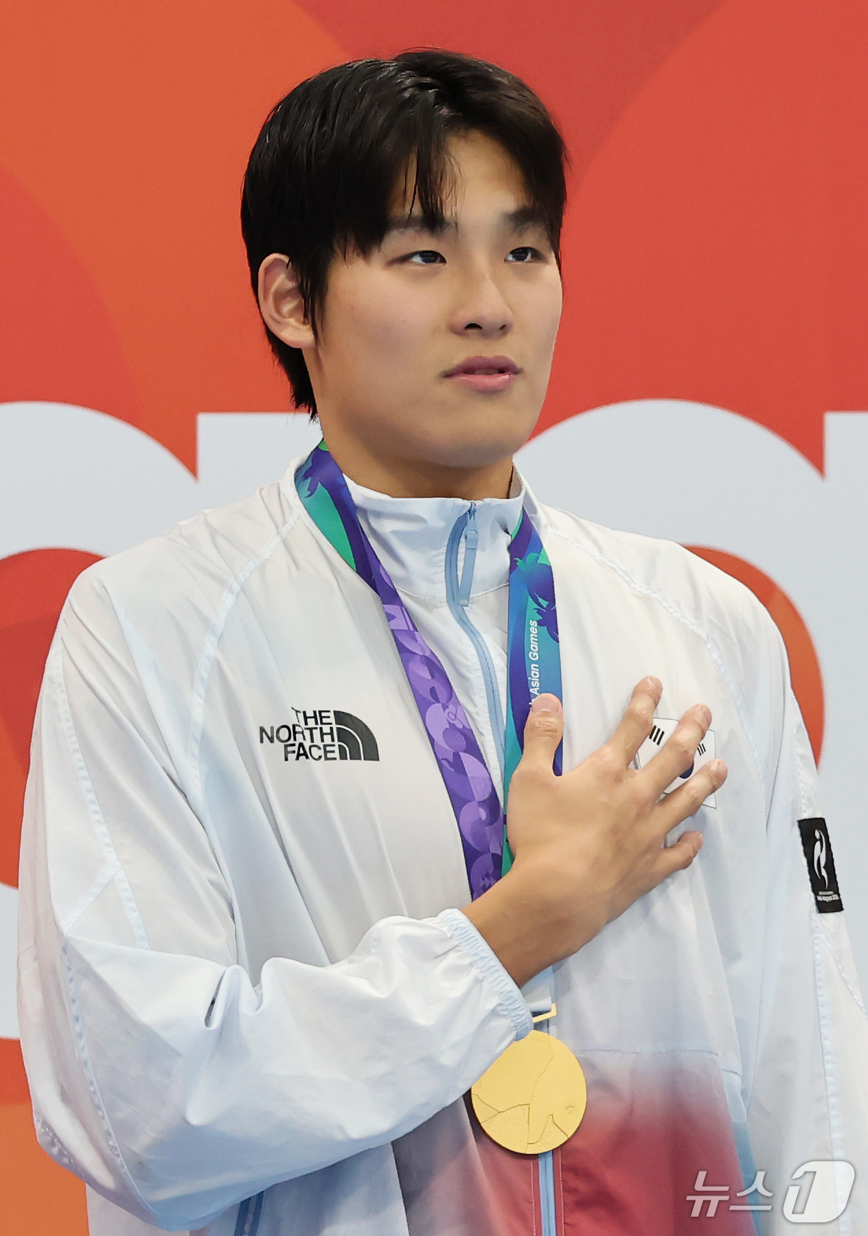 (도쿄=뉴스1) 김민지 기자 = 21일 도쿄 아쿠아틱스 센터에서 열린 2026 아이치·나고야 아시안게임 남자 50m 자유형 결승전에서 금메달을 획득한 김영범이 시상대에 올라 태극기 …
