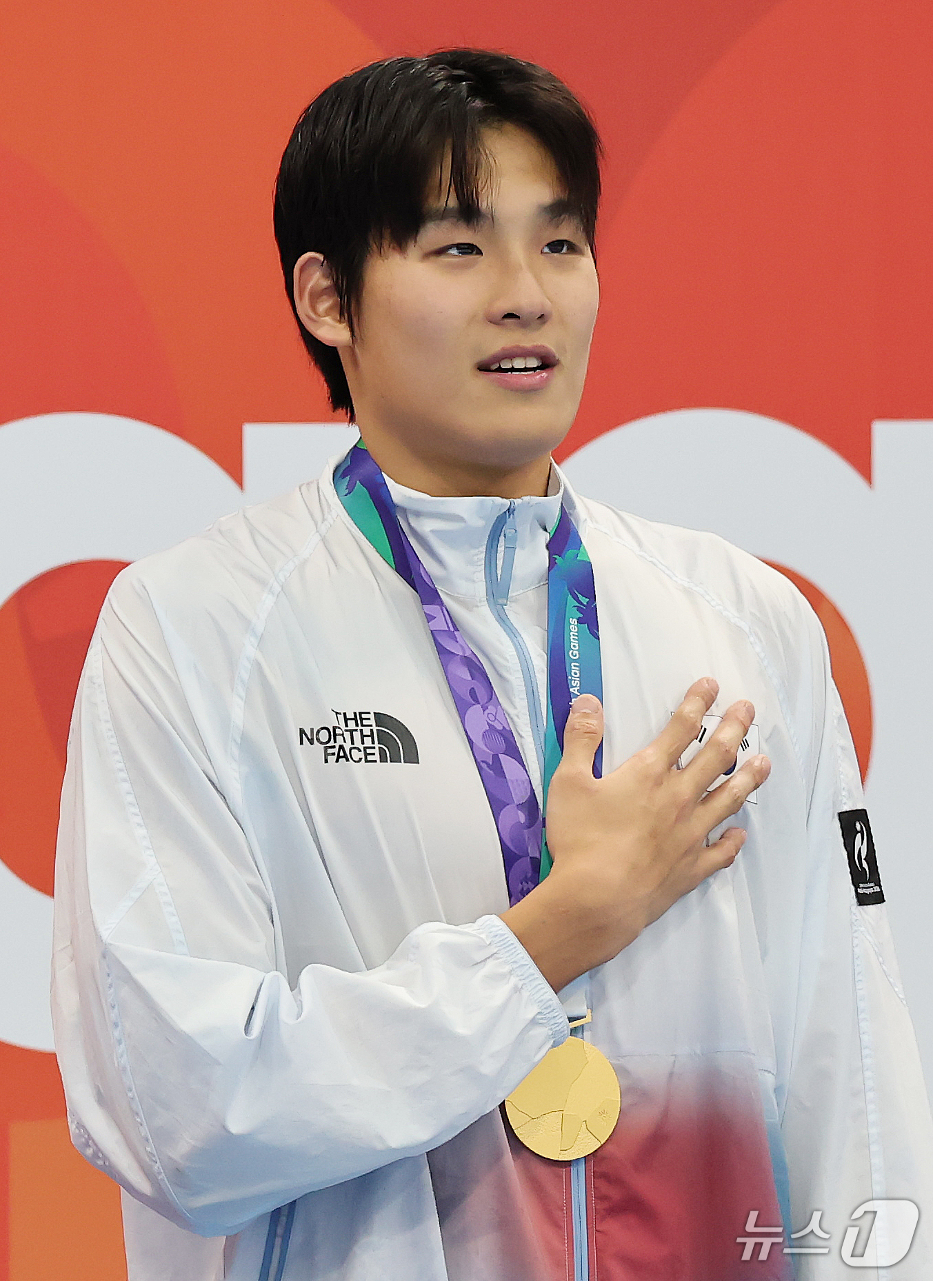 (도쿄=뉴스1) 김민지 기자 = 21일 도쿄 아쿠아틱스 센터에서 열린 2026 아이치·나고야 아시안게임 남자 50m 자유형 결승전에서 금메달을 획득한 김영범이 시상대에 올라 태극기 …
