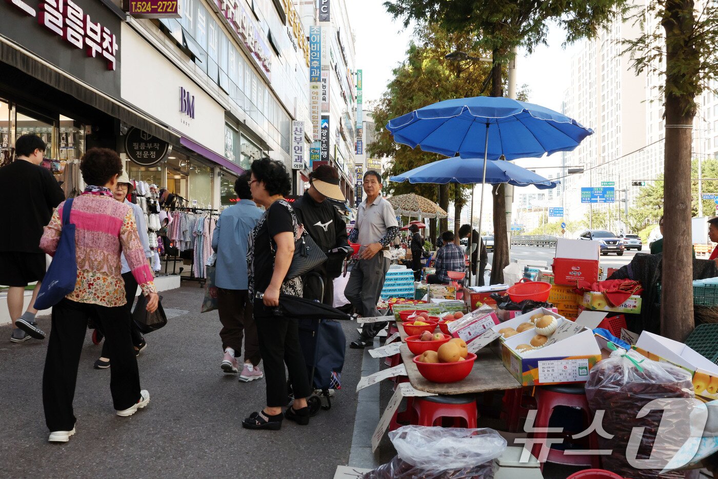 본문 이미지 - 추석을 앞둔 22일 전남광주 북구 운암동 북문대로 일대 노점에서 시민들이 과일 등 제수용품을 살펴보거나 보도를 지나고 있다 ⓒ 뉴스1 박지현 기자