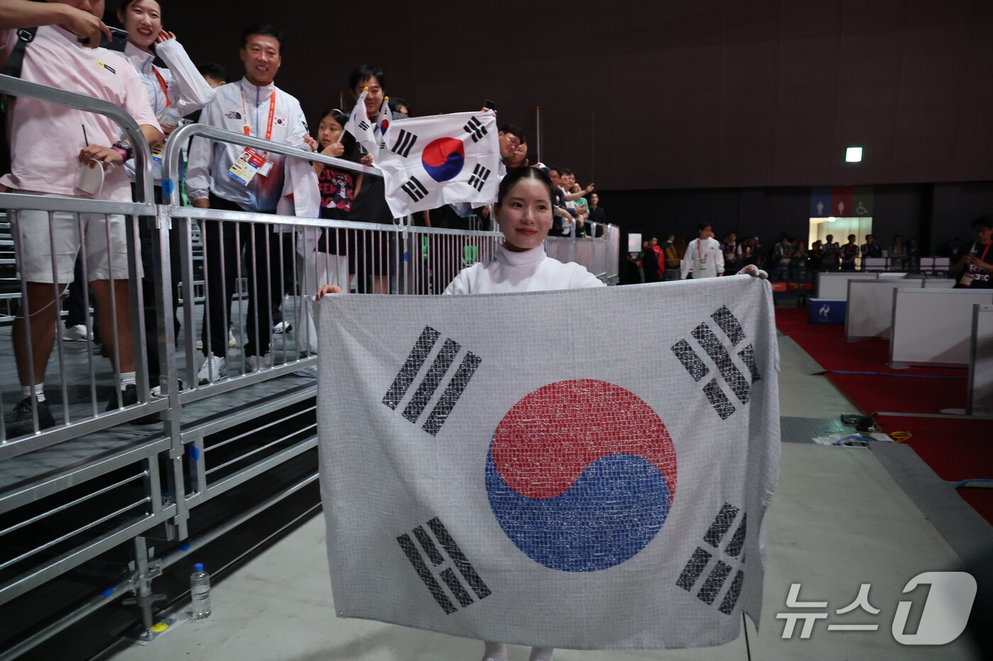본문 이미지 - 대한민국 송세라가 21일 일본 아이치 스카이 엑스포홀에서 열린 2026 아이치·나고야 아시안게임 펜싱 여자 에페 결승에서 싱가포르의 키리아 티카나를 꺾고 금메달을 차지한 뒤 태극기를 들고 있다. 2026.9.22 ⓒ 뉴스1 안은나 기자