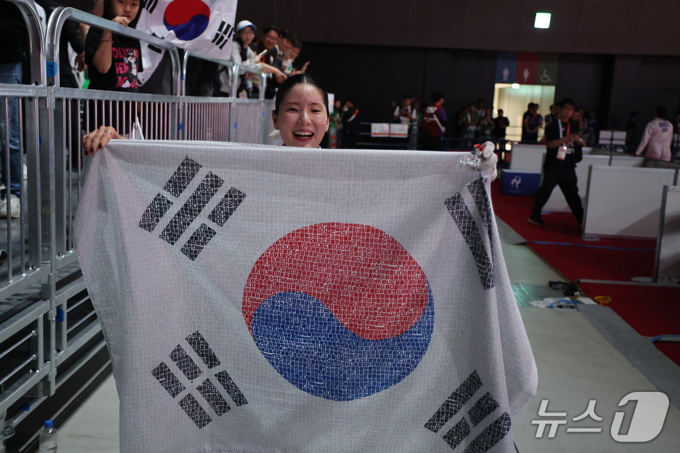 본문 이미지 - 대한민국 송세라가 21일 일본 아이치 스카이 엑스포홀에서 열린 2026 아이치·나고야 아시안게임 펜싱 여자 에페 결승에서 싱가포르의 키리아 압둘을 꺾고 금메달을 차지한 뒤 태극기를 들고 있다. 2026.9.22 ⓒ 뉴스1 안은나 기자