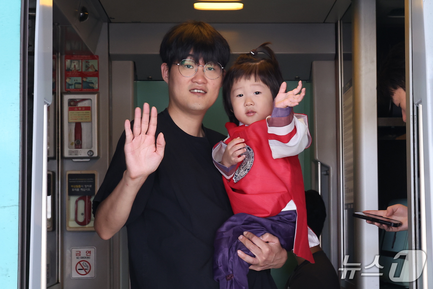 (서울=뉴스1) 김성진 기자 = 추석 연휴를 하루 앞둔 23일 서울역에서 한 가족이 열차에 탑승해 인사하고 있다. 2026.9.23/뉴스1