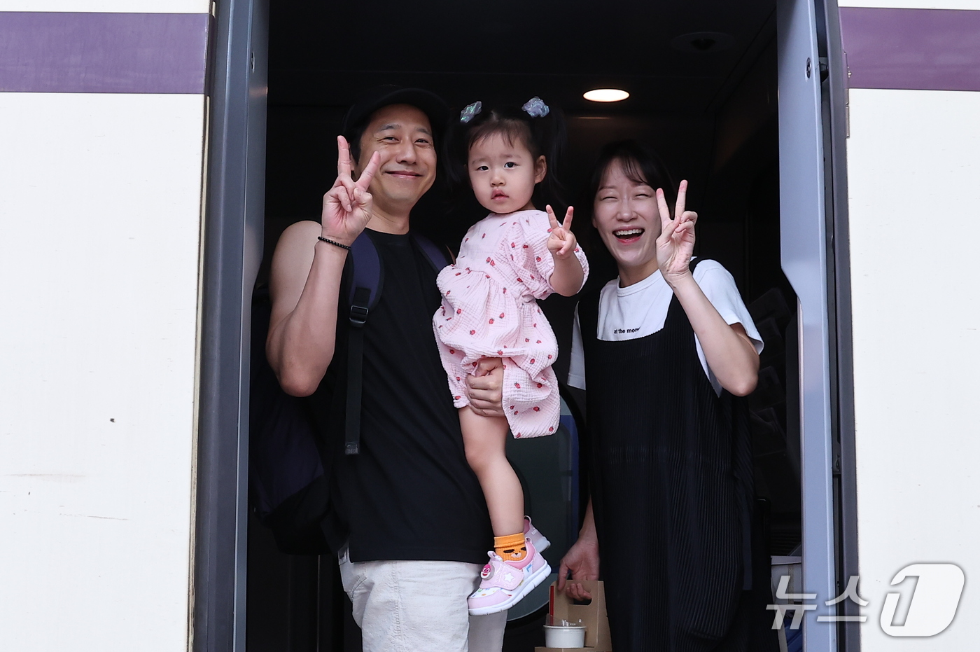 (서울=뉴스1) 김성진 기자 = 추석 연휴를 하루 앞둔 23일 서울역에서 한 가족이 열차에 탑승해 인사하고 있다. 2026.9.23/뉴스1